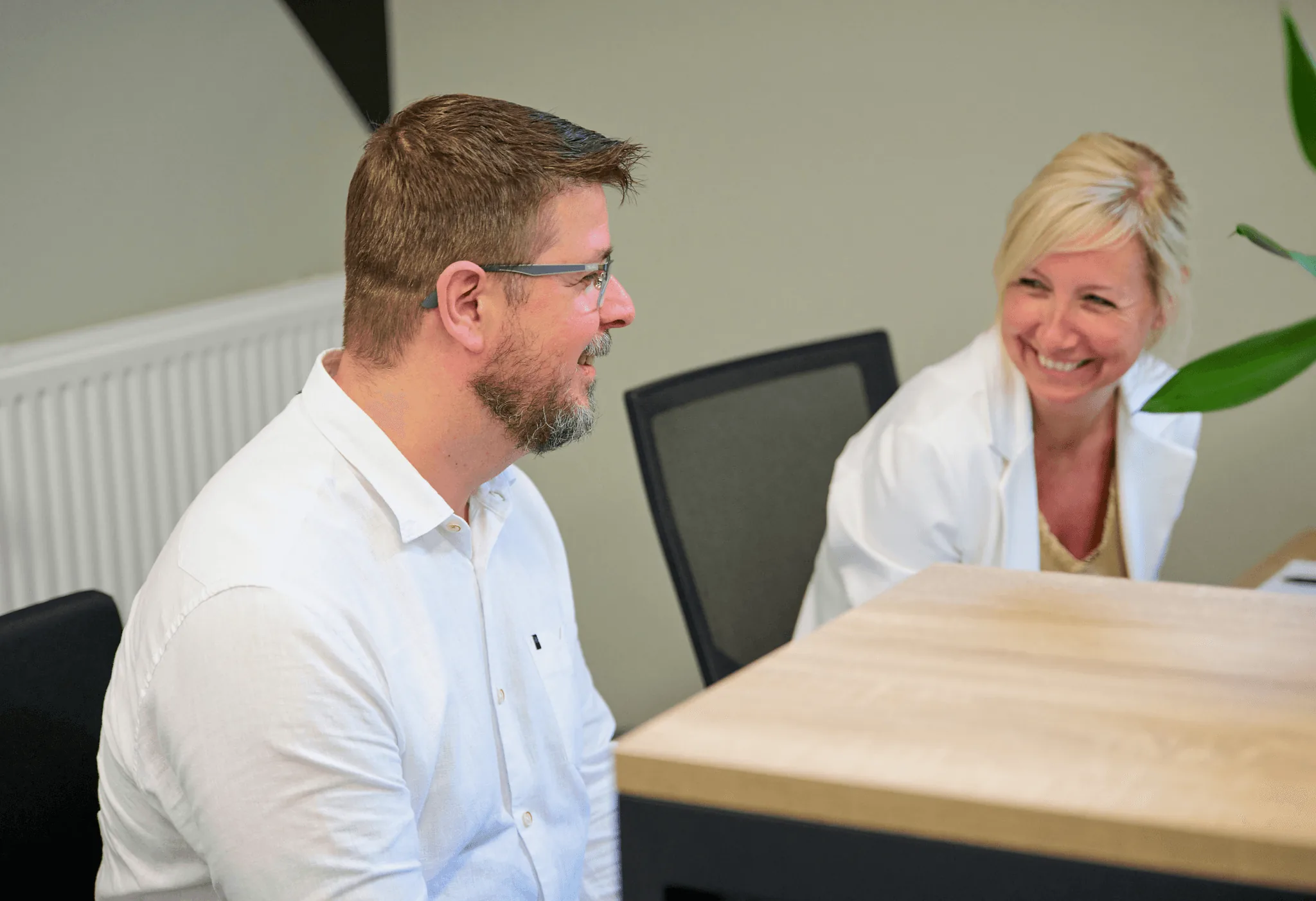 Twee Westers-collega's in gesprek op kantoor