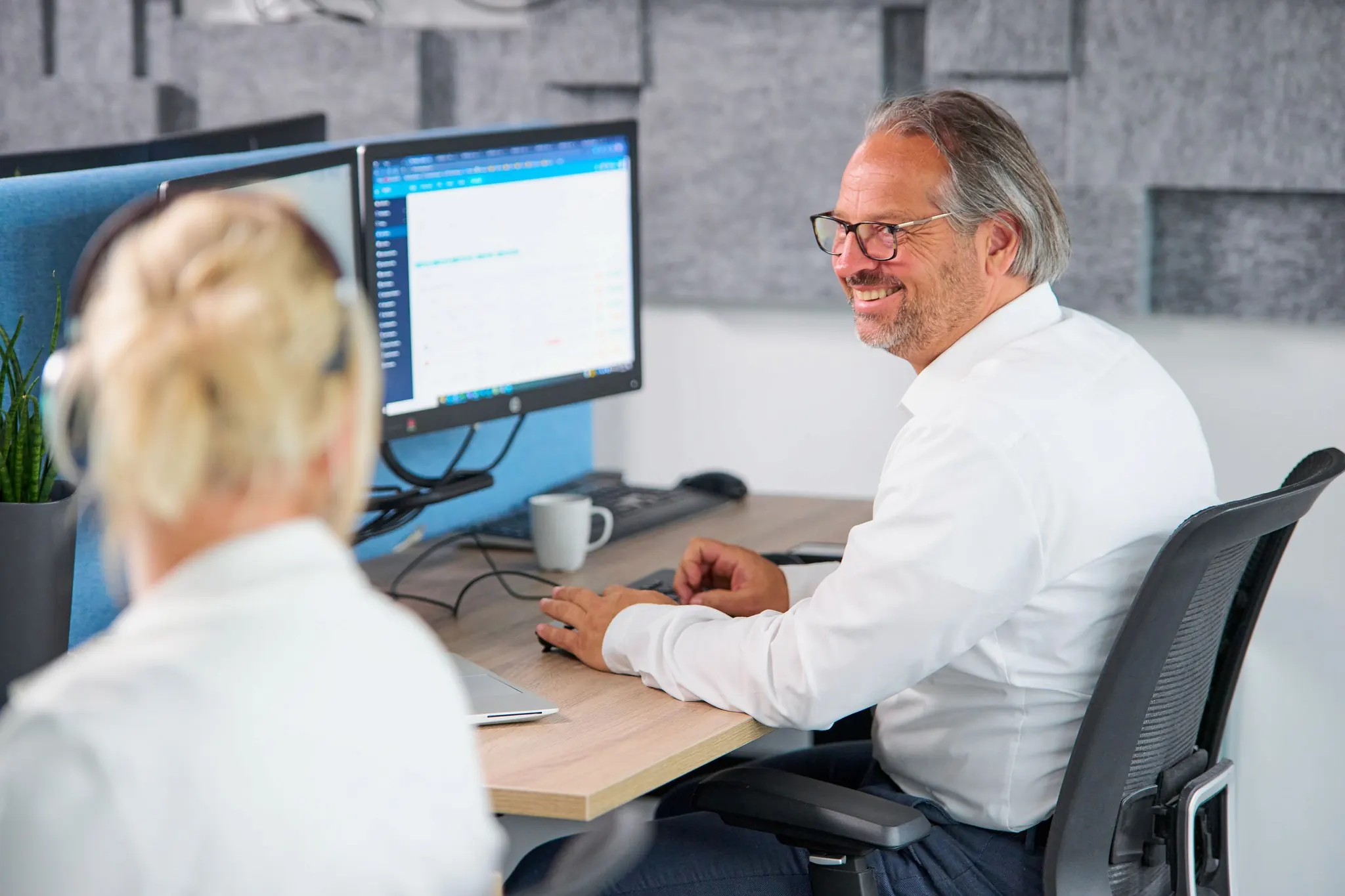 ICT Medewerker lachend werkend achter zijn beeldscherm