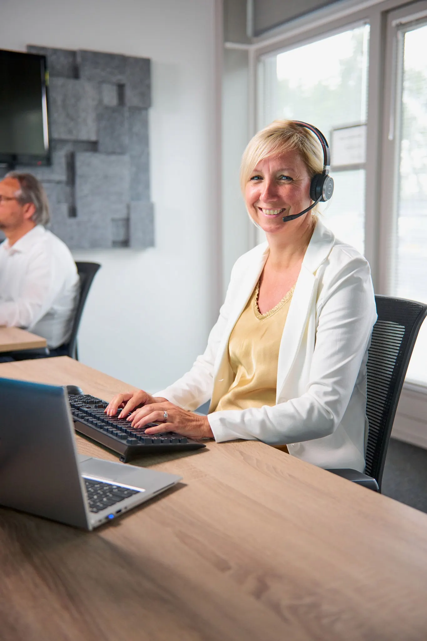 ICT Servicemedewerkster achter haar bureau met bel headset op